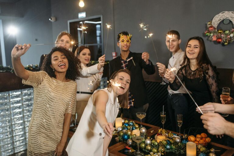 Group of diverse colleagues celebrating with sparklers at an office party.