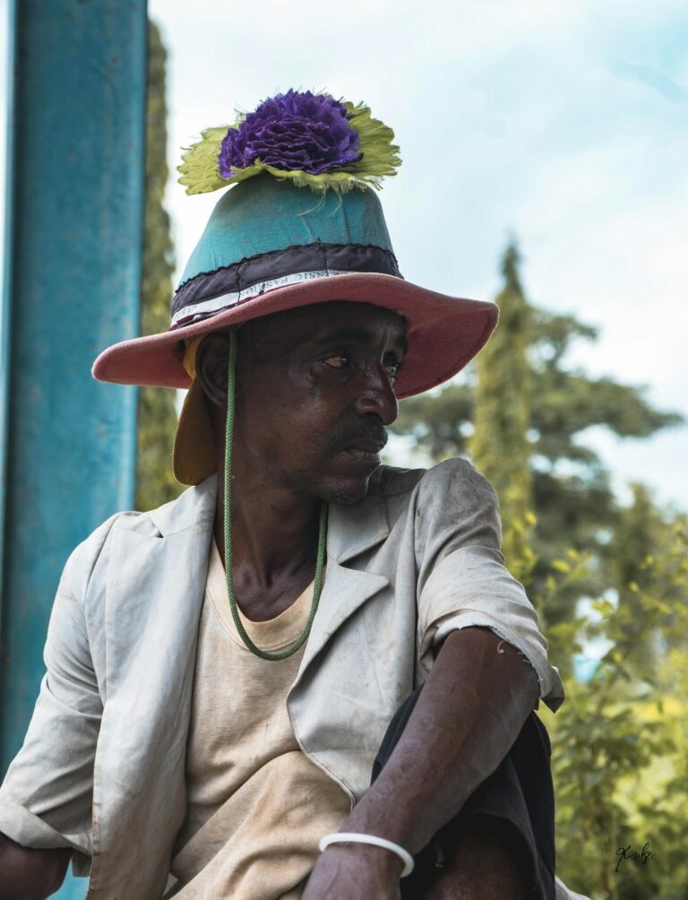 Portrait of a man in vibrant traditional attire and a colorful hat in Abuja, Nigeria.